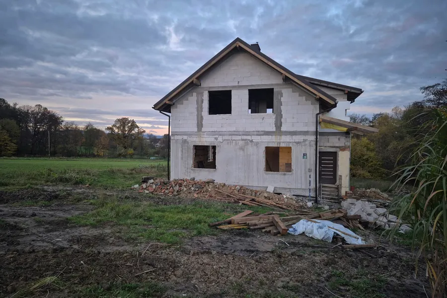 Stary budynek w przebudowie — nowa kondygnacja z bloczków i dach