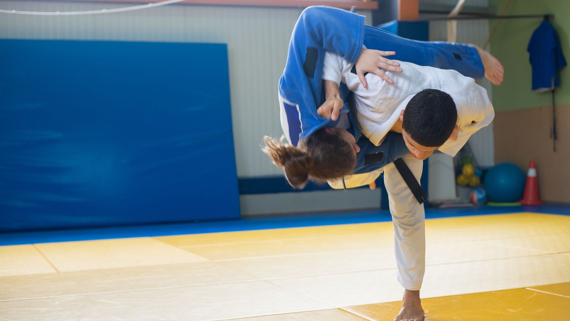 Dwaj judocy podczas rzutu na macie treningowej